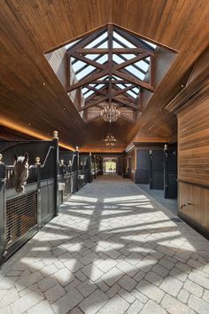 the inside of a horse stable with wooden walls and ceilings, along with stone flooring