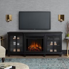 a living room with a fireplace and television on the wall in front of an entertainment center