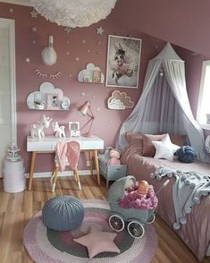 a bedroom with pink walls and wooden floors, decorated in pastel colors for girls