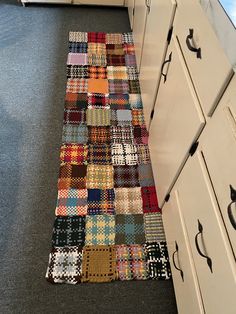 a patchwork rug is on the kitchen floor next to an oven and cupboards