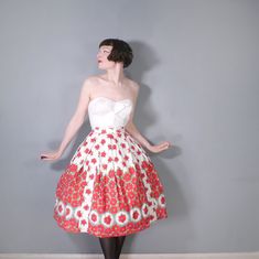 Fantastic and so romantic 50s vivid red floral skirt in white cotton. Lovely border design with smaller scattered flowers to the upper skirt and a thicker border pattern which feature small framed floral designs towards the hem. Small vertical panels have been sewn in to create a contrasting effect, very clever! High fitted waist band with button and metal zip fastening. Full fit with box pleats. Light cotton. Midi length. No labels. Skirt is pictured with a petticoat which is not included in th Vintage White Full Skirt, White Retro Full Skirt, Retro White Full Skirt, Vintage Red Fitted Petticoat, Fitted Red Petticoat For Spring, White Full Skirt For Garden Party, Vintage White Floral Print Skirt, Vintage Red Floral Print Skirt, Red Vintage Floral Print Skirt