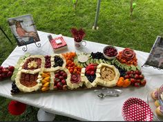 a table topped with lots of fruits and veggies on top of a white table cloth