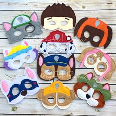 several masks with different colors and designs on wooden surface, including one wearing a mask