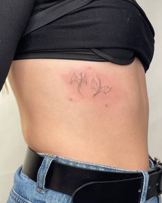 a woman's stomach with the word love tattooed on her lower side ribcage