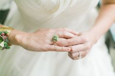 a close up of a person wearing a wedding dress holding the hand of another person