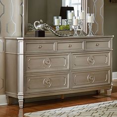 a dresser with a mirror on top of it in a room next to a rug