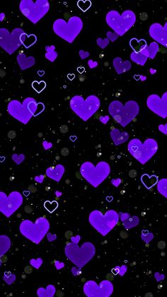 purple hearts floating in the air on a black background