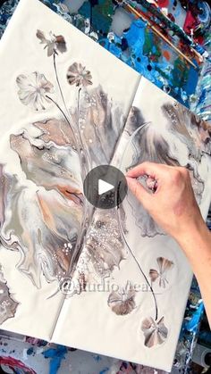 a person is painting flowers with acrylic paint on white paper and black ink