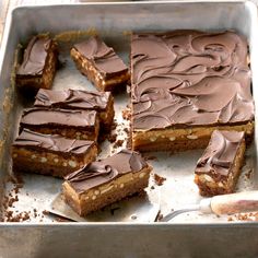 there are many pieces of chocolate cake on the baking sheet, ready to be eaten