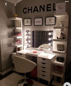 a room with a vanity, mirror and lights on the wall next to a chair