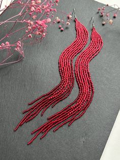 Long Red Beaded Fringe Earrings Add a vibrant touch to your outfit with these stylish long red beaded earrings. Handcrafted, these earrings captivate with their rich red color and elegant fringe, adding dynamism and lightness. These earrings are perfect for any occasion, whether it's a casual day out or an evening event. Lightweight and comfortable to wear, they will become your favorite accessory. Features: Lightweight and comfortable to wear. Unique design. Perfect gift. Made from Czech beads. Hypoallergenic clasp. Length 9 inches (23cm). Width 0.5 inches (1.5cm). If you want these earrings in a different color, write to me and I will be happy to make them for you. Extra Long Beaded Earrings, Elegant Red Tassel Drop Earrings, Elegant Red Tassel Earrings As Gift, Elegant Red Tassel Earrings For Gift, Red Tassel Drop Earrings For Pierced Ears, Handmade Red Beaded Long Drop Earrings, Handmade Red Tassel Earrings, Elegant Style, Handmade Red Long Drop Beaded Earrings, Red Long Drop Earrings With Ear Wire