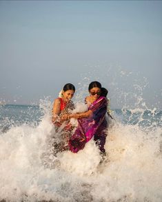 two women splashing in the ocean on their stomachs