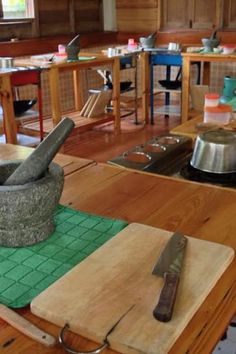 a kitchen area with cutting board, utensils and pots on the counter