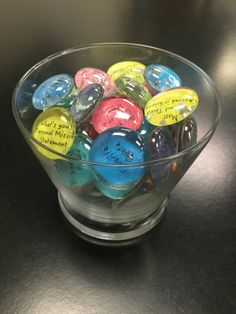 a glass bowl filled with lots of different colored candies on top of a table