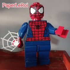 a lego spider - man is standing on a table