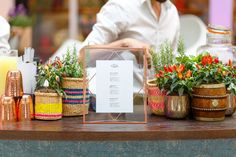 a table topped with lots of potted plants next to a menu on top of a wooden table