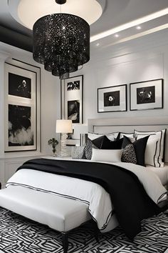 a black and white bedroom with chandelier, bed, pictures on the wall