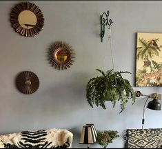 a living room filled with furniture and lots of plants on the wall next to it