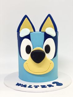 a blue and yellow cake with a dog face on it