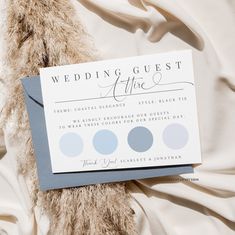 a wedding guest card sitting on top of a white sheet with blue and gray circles