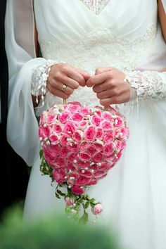 a bride holding a bouquet of pink roses in her hands with the caption, i do not know what this image is