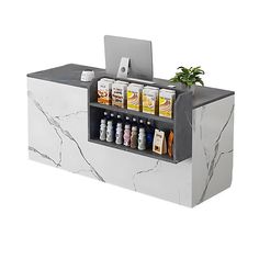 a white counter topped with a laptop computer and lots of condiments on it