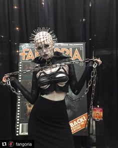 a woman in a costume with chains attached to her body and wearing a skeleton mask