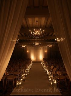 the aisle is lined with candles and chairs