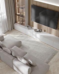 a living room with a large couch and flat screen tv mounted on the wall above it