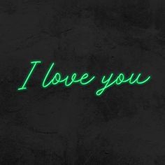 the words i love you are lit up in green on a black background with dark shadows