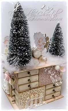 there is a small christmas tree on top of an old dresser with other ornaments and decorations