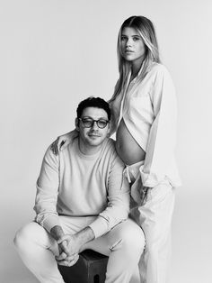 a man and woman are posing for a black and white photo with one holding the other's leg