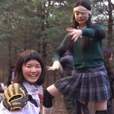 two girls in school uniforms are playing frisbee