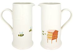 two white vases with bees on them and one has a beehive painted on it