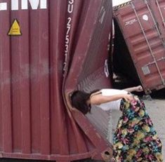 a woman leaning against the side of a train car with her hand on it's door