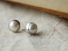 Simple yet elegant stud earrings feature stunning freshwater pearls accentuated by sterling silver settings. Silver Jewelry With Pearl Buttons As Gift, Silver Everyday Pearl Pendant Earrings, Silver Pearl Pendant Earrings For Everyday, Earring Pearl, Sterling Silver Earrings Handmade, Earring Handmade, Labradorite Earrings, Gemstone Stud Earrings, Pearl Earring