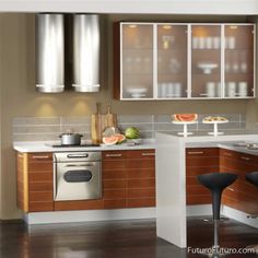 a modern kitchen with stainless steel appliances and wood cabinets