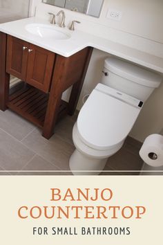 a white toilet sitting next to a sink in a bathroom under a wooden vanity mirror