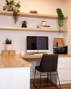 an instagram photo of a desk with a computer on it and some plants in the corner