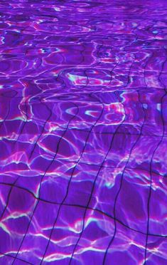 an image of water that is purple and has some light reflecting on the surface in it