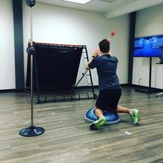 a man swinging a tennis racquet on top of a ball in front of a tv