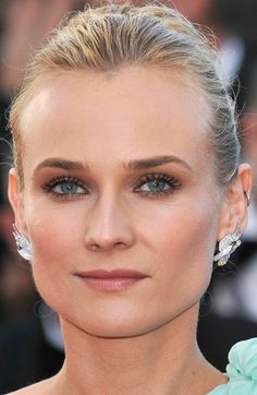 a woman with blonde hair and blue eyes in front of photographers on the red carpet