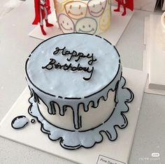 a birthday cake sitting on top of a white table next to other cakes and decorations