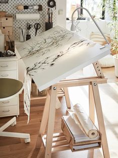 an artist's easel sitting on top of a hard wood floor next to a desk