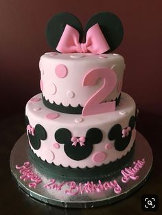 a two tiered birthday cake decorated with minnie mouse ears