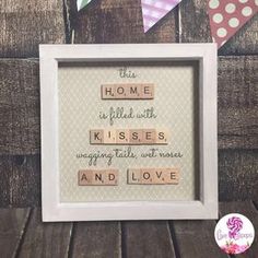 a wooden scrabble frame with the words, this home is filled with kisses and hugs