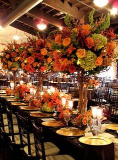 a long table is set up with candles and centerpieces for an elegant dinner