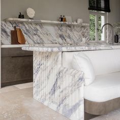 a marble counter top in a kitchen next to a white couch