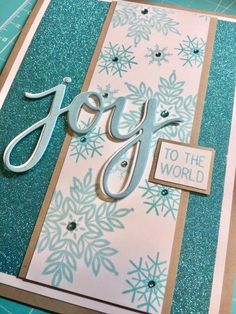 a card with the word joy on it and snowflakes in the back ground