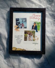 a birthday card with pictures of women and flowers is displayed in a black frame on a white sheet